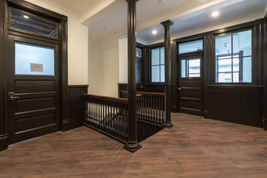 Inspiration for a mid-sized transitional vinyl floor, brown floor and wainscoting entryway remodel in Other with white walls and a metal front door