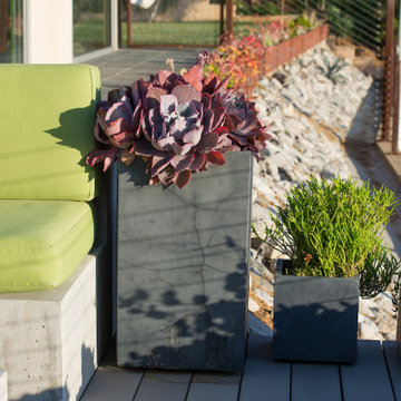 Succulents in pots next to built-in outdoor seating on deck