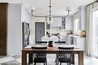 Example of a mid-sized transitional u-shaped porcelain tile and gray floor kitchen pantry design in Toronto with an undermount sink, recessed-panel cabinets, blue cabinets, quartzite countertops, white backsplash, porcelain backsplash, stainless steel appliances, an island and white countertops