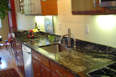 Enclosed kitchen - small transitional single-wall light wood floor and beige floor enclosed kitchen idea in DC Metro with an undermount sink, flat-panel cabinets, light wood cabinets, granite countertops, stainless steel appliances and no island