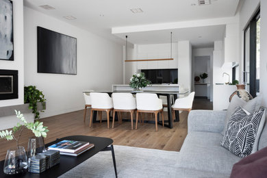 Example of a minimalist living room design in Melbourne with white walls