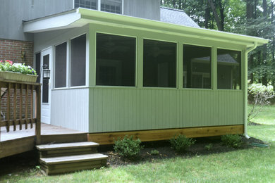 Design ideas for a mid-sized transitional backyard screened-in verandah in Baltimore with decking and a roof extension.