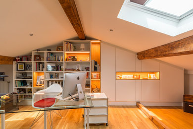 Imagen de despacho ecléctico con paredes grises y suelo de madera en tonos medios