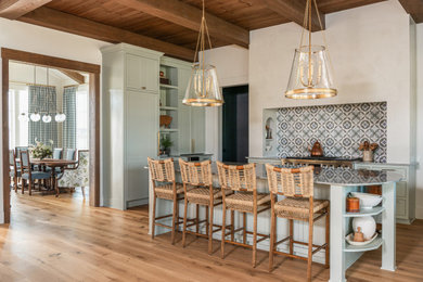 Example of a mid-sized cottage medium tone wood floor, brown floor and wood ceiling open concept kitchen design in Houston with a drop-in sink, shaker cabinets, green cabinets, quartzite countertops, multicolored backsplash, marble backsplash, paneled appliances, an island and multicolored countertops