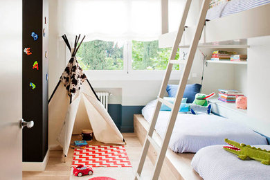 Small scandinavian gender-neutral kids' bedroom in Barcelona with beige walls and light hardwood floors for kids 4-10 years old.