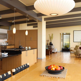This is an example of a large midcentury open plan dining in Seattle with beige walls, medium hardwood floors and no fireplace.