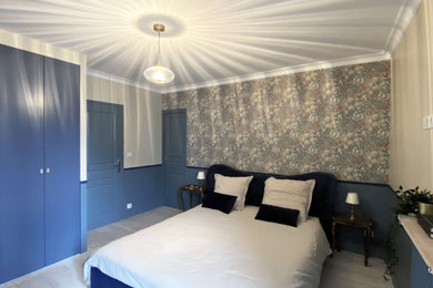Diseño de dormitorio principal minimalista de tamaño medio sin chimenea con paredes azules, suelo de madera clara, suelo marrón y papel pintado