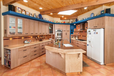 Inspiration for an eclectic kitchen remodel in Albuquerque with an undermount sink, shaker cabinets, light wood cabinets, white appliances and an island