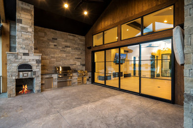 Example of a large minimalist backyard concrete patio kitchen design in Denver