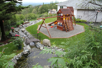 This is an example of a large contemporary backyard full sun garden for summer in Other with gravel.