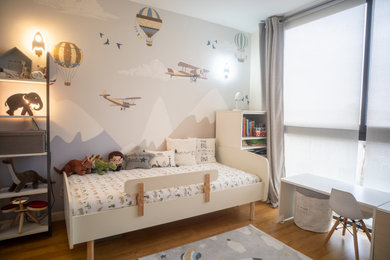 Inspiration pour une chambre de garçon de 4 à 10 ans minimaliste avec un mur bleu et parquet clair.