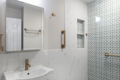 Inspiration for a mid-sized mediterranean green tile and porcelain tile porcelain tile, white floor, single-sink and wainscoting bathroom remodel in DC Metro with a two-piece toilet, gray walls, a pedestal sink, solid surface countertops, white countertops and a niche