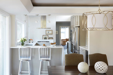 Large transitional u-shaped dark wood floor and brown floor eat-in kitchen photo in Chicago with a peninsula, shaker cabinets, gray cabinets, an undermount sink, quartzite countertops, stainless steel appliances, white backsplash and porcelain backsplash
