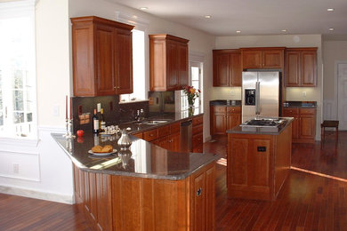 Mid-sized elegant l-shaped medium tone wood floor and brown floor eat-in kitchen photo in Boston with an undermount sink, raised-panel cabinets, medium tone wood cabinets, granite countertops, stone slab backsplash, stainless steel appliances, an island and brown backsplash