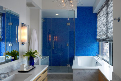 Trendy blue tile corner shower photo in New York with an undermount sink, flat-panel cabinets, light wood cabinets, an undermount tub and white walls