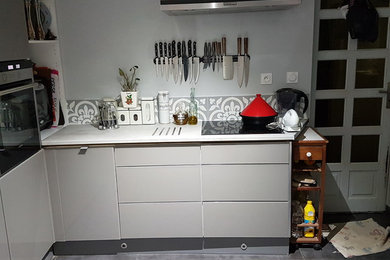 Cette image montre une grande cuisine américaine design en L avec un évier encastré, un placard à porte vitrée, des portes de placard grises, plan de travail carrelé, une crédence grise, un sol en carrelage de céramique, 2 îlots, un sol gris et un plan de travail gris.