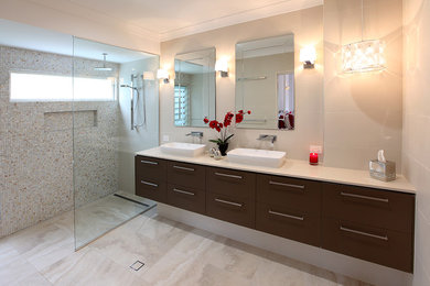 Inspiration for a large contemporary master bathroom in Brisbane with a one-piece toilet, brown cabinets, an open shower, beige tile, porcelain tile, porcelain floors, a drop-in sink and solid surface benchtops.