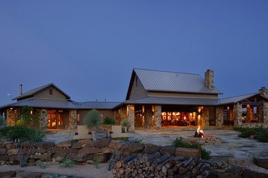 Country two-storey exterior in Austin with stone veneer.