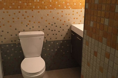 Example of a mid-sized trendy multicolored tile and glass tile porcelain tile powder room design in Other with multicolored walls