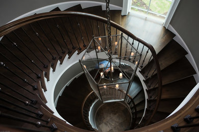 Photo of an expansive beach style wood spiral staircase in Other with wood risers and mixed railing.