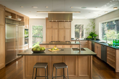 This is an example of an expansive contemporary u-shaped kitchen in San Francisco with an undermount sink, shaker cabinets, light wood cabinets, stainless steel appliances, dark hardwood floors, multiple islands, brown floor and grey benchtop.