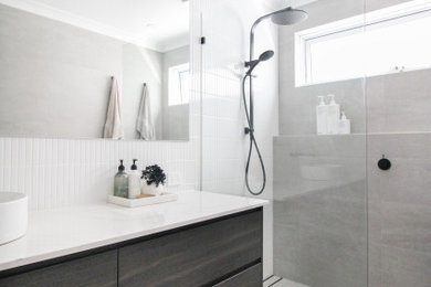Mid-sized modern kids bathroom in Perth with furniture-like cabinets, black cabinets, an open shower, white tile, ceramic tile, grey walls, porcelain floors, a vessel sink, engineered quartz benchtops, grey floor, an open shower, white benchtops, a single vanity and a floating vanity.