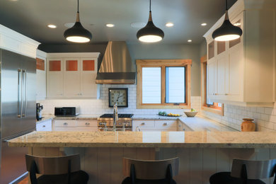 Mid-sized danish u-shaped medium tone wood floor and brown floor eat-in kitchen photo in Salt Lake City with a farmhouse sink, shaker cabinets, white cabinets, granite countertops, white backsplash, subway tile backsplash, stainless steel appliances, a peninsula and beige countertops