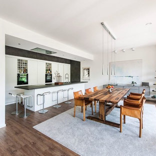 Offenes, Großes Modernes Esszimmer ohne Kamin mit weißer Wandfarbe, dunklem Holzboden und braunem Boden in Hamburg