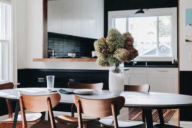 Kitchen/dining room combo - mid-sized scandinavian light wood floor and white floor kitchen/dining room combo idea in Minneapolis with white walls, a standard fireplace and a stone fireplace