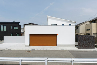 Imagen de fachada de casa blanca y negra grande de dos plantas con tejado de un solo tendido y tejado de metal