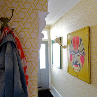 Photo of an eclectic entryway in London with yellow walls.