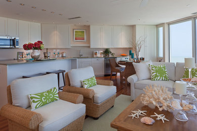 Mid-sized beach style single-wall medium tone wood floor open concept kitchen photo in Tampa with a drop-in sink, shaker cabinets, white cabinets, granite countertops, white backsplash, stainless steel appliances and an island