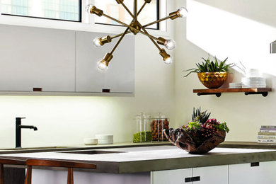 Example of a mid-sized urban l-shaped kitchen design in Vancouver with an undermount sink, flat-panel cabinets, white cabinets, concrete countertops and an island