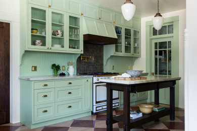 Example of a large arts and crafts medium tone wood floor kitchen pantry design in Los Angeles with a farmhouse sink, shaker cabinets, green cabinets, quartzite countertops, green backsplash, ceramic backsplash, an island and green countertops