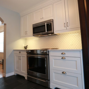 Small traditional kitchen pantry designs - Kitchen pantry - small traditional galley slate floor kitchen pantry idea in Montreal with a farmhouse sink, shaker cabinets, white cabinets, quartzite countertops, white backsplash, ceramic backsplash, stainless steel appliances and no island