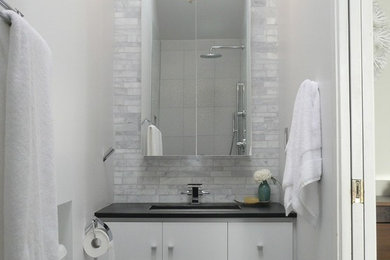 Inspiration for a small transitional master bathroom in Edmonton with flat-panel cabinets, white cabinets, an alcove shower, a two-piece toilet, white tile, marble, white walls, porcelain floors, an undermount sink, soapstone benchtops, grey floor and an open shower.