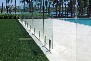 Inspiration for a large contemporary back rectangular infinity swimming pool in Orlando with natural stone paving.