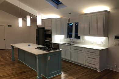 Open concept kitchen - large single-wall medium tone wood floor open concept kitchen idea in Nashville with an undermount sink, shaker cabinets, white cabinets, quartz countertops, white backsplash, marble backsplash, stainless steel appliances, an island and white countertops
