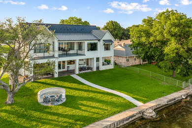 Inspiration for a mid-sized transitional white two-story concrete fiberboard and board and batten exterior home remodel in Dallas with a metal roof and a gray roof