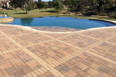 Inspiration for a large mediterranean backyard kidney-shaped and concrete paver infinity pool remodel in San Diego