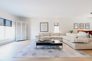 Living room - large scandinavian formal and open concept light wood floor and beige floor living room idea in Montreal with white walls and a wall-mounted tv