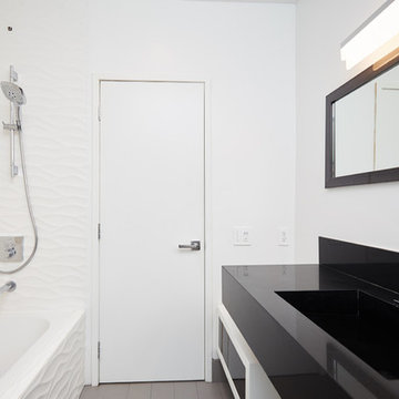 Full Bathroom Layout With Black Stone Vanity and Tub