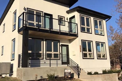 Example of a large trendy beige two-story concrete exterior home design in Kansas City