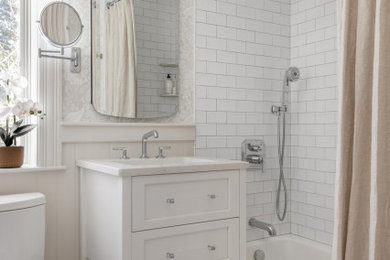 Bathroom - traditional white tile and ceramic tile porcelain tile, single-sink and wallpaper bathroom idea in Boston with shaker cabinets, white cabinets, a two-piece toilet, beige walls, an undermount sink, quartz countertops, beige countertops and a freestanding vanity