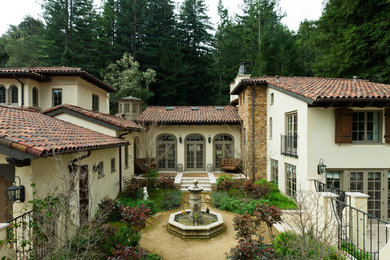 Example of a large tuscan white two-story stucco exterior home design in San Francisco with a tile roof