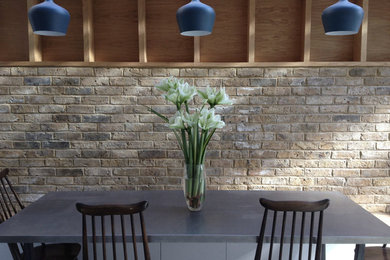 Mid-sized contemporary galley open plan kitchen in London with concrete floors.