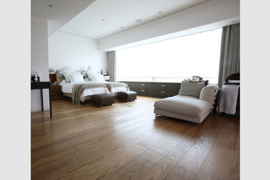 Cette photo montre une grande chambre tendance avec un mur blanc, parquet foncé et un sol marron.