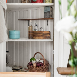 Mid-sized midcentury modern kitchen pantry ideas - Mid-sized midcentury modern single-wall painted wood floor and white floor kitchen pantry photo in Gothenburg with a double-bowl sink, open cabinets, white cabinets, white backsplash, porcelain backsplash, white appliances and brown countertops