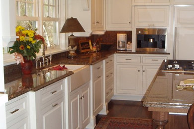 Example of a huge classic u-shaped medium tone wood floor open concept kitchen design in Minneapolis with a farmhouse sink, beaded inset cabinets, white cabinets, granite countertops, brown backsplash, stone slab backsplash and white appliances
