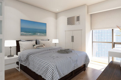 Example of a small beach style laminate floor and brown floor bedroom design in Other with white walls